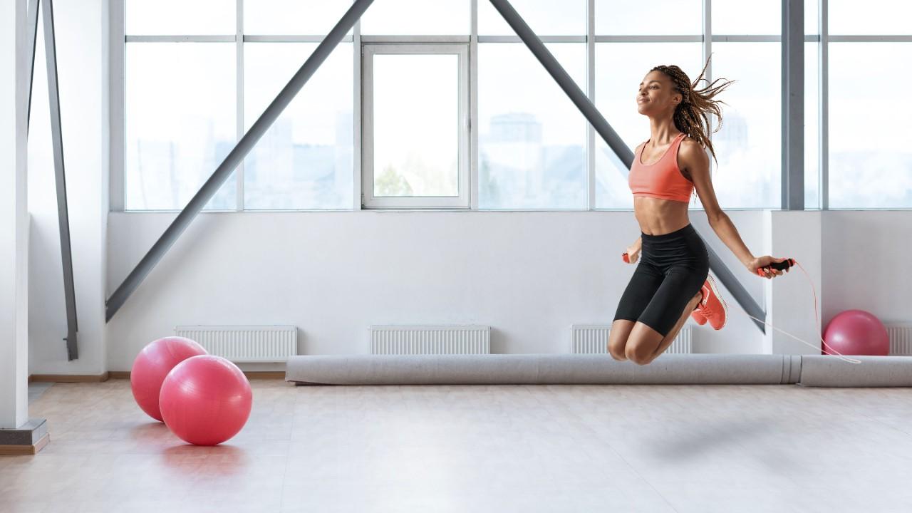 Young african woman skipping rope while exercising