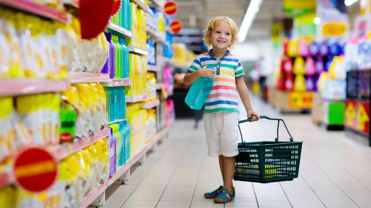 Child in supermarket buying fruit and juice. 孩子们去杂货店购物. Little boy with cart choosing fresh vegetables in local store.